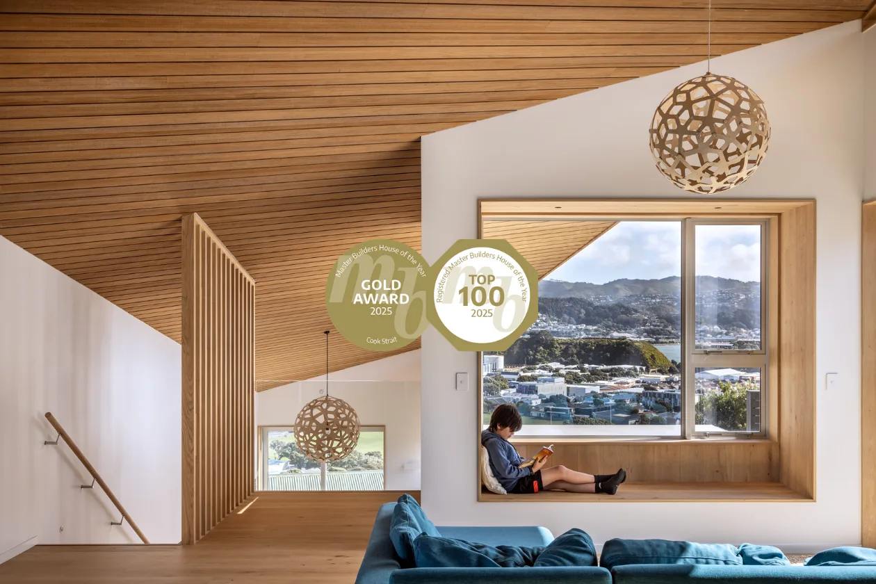 Award-winning contemporary home interior featuring warm timber ceilings, a built-in window seat and expansive Wellington views, with 2025 Master Builders Gold Award and Top 100 badges.