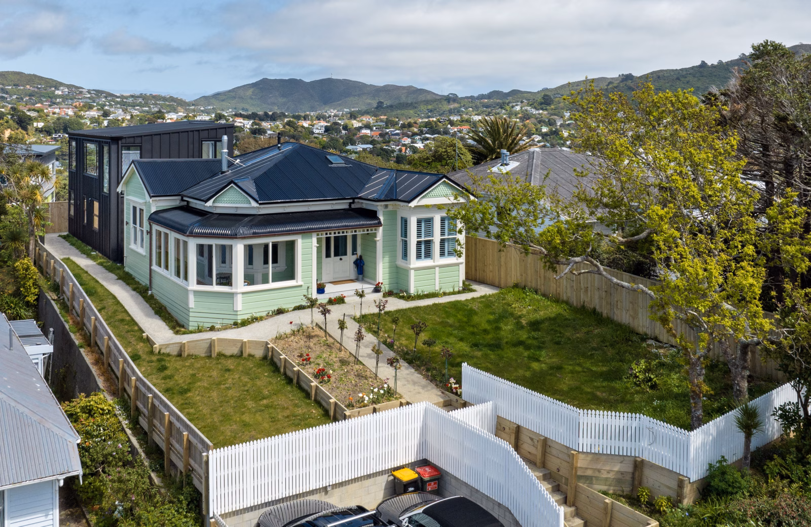 High-end house renovation in Wellington: a restored character villa with a modern two-storey extension, landscaped garden and white picket fence